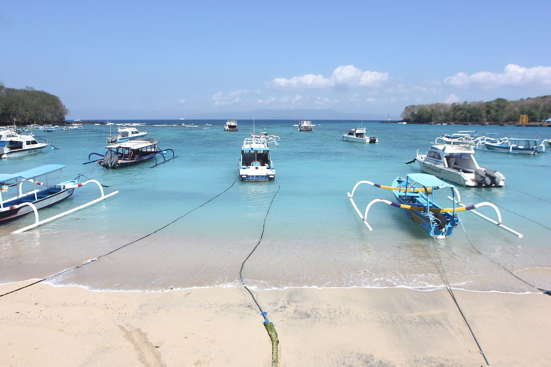 Traditionele jukung-boten op turquoise water bij Padangbai